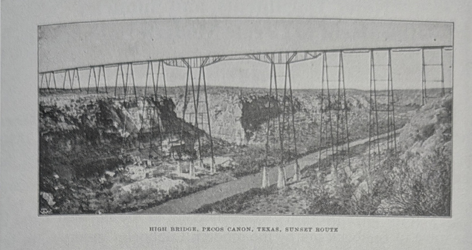 A halftone photograph of a long steel trestle carried on tall latticed towers across a rocky canyon, with a road or track running along the canyon floor beneath it. Printed beneath the image: HIGH BRIDGE, PECOS CANON, TEXAS, SUNSET ROUTE.